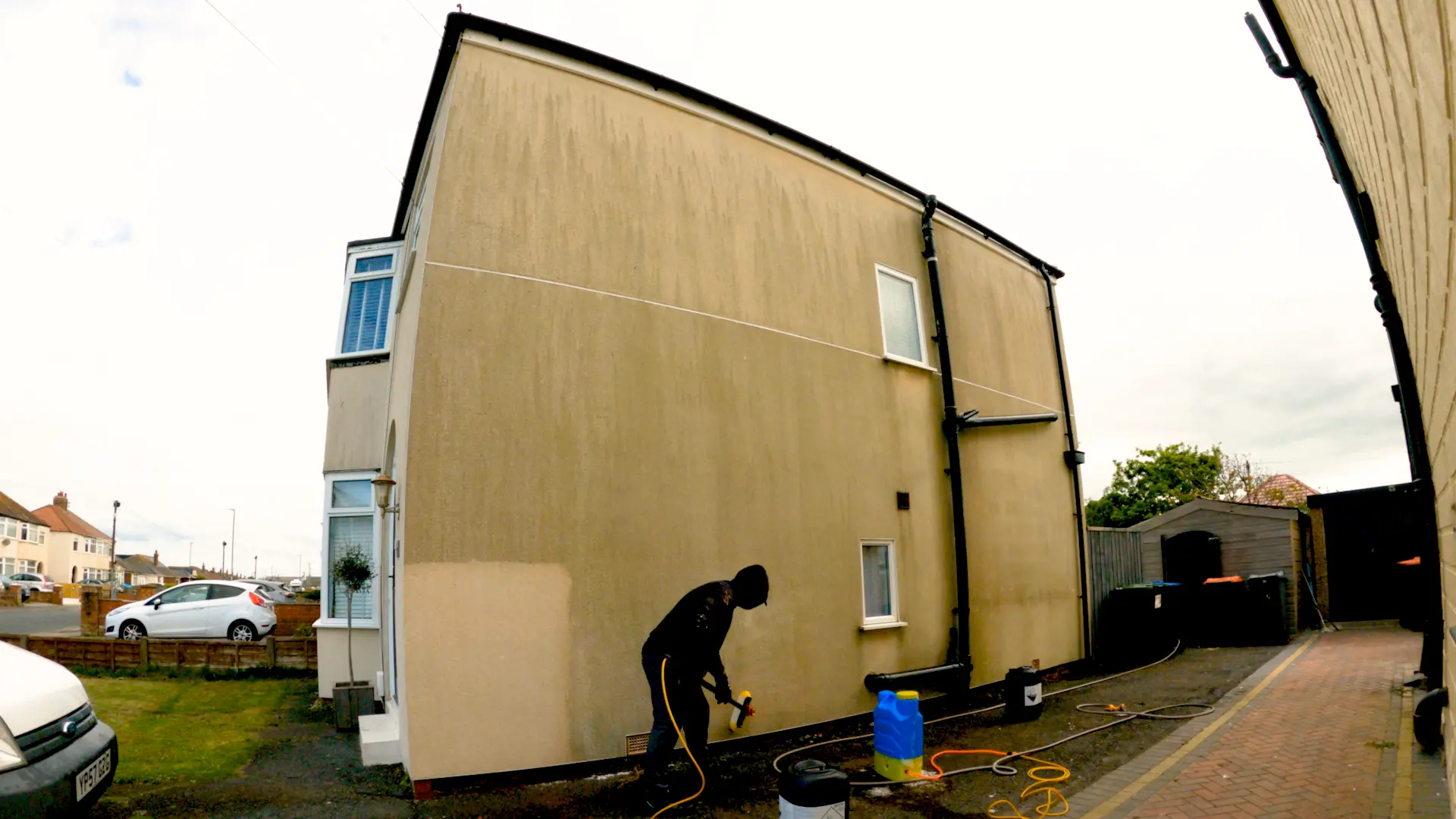 Large rendered gable wall with dark streaking and staining before soft washing