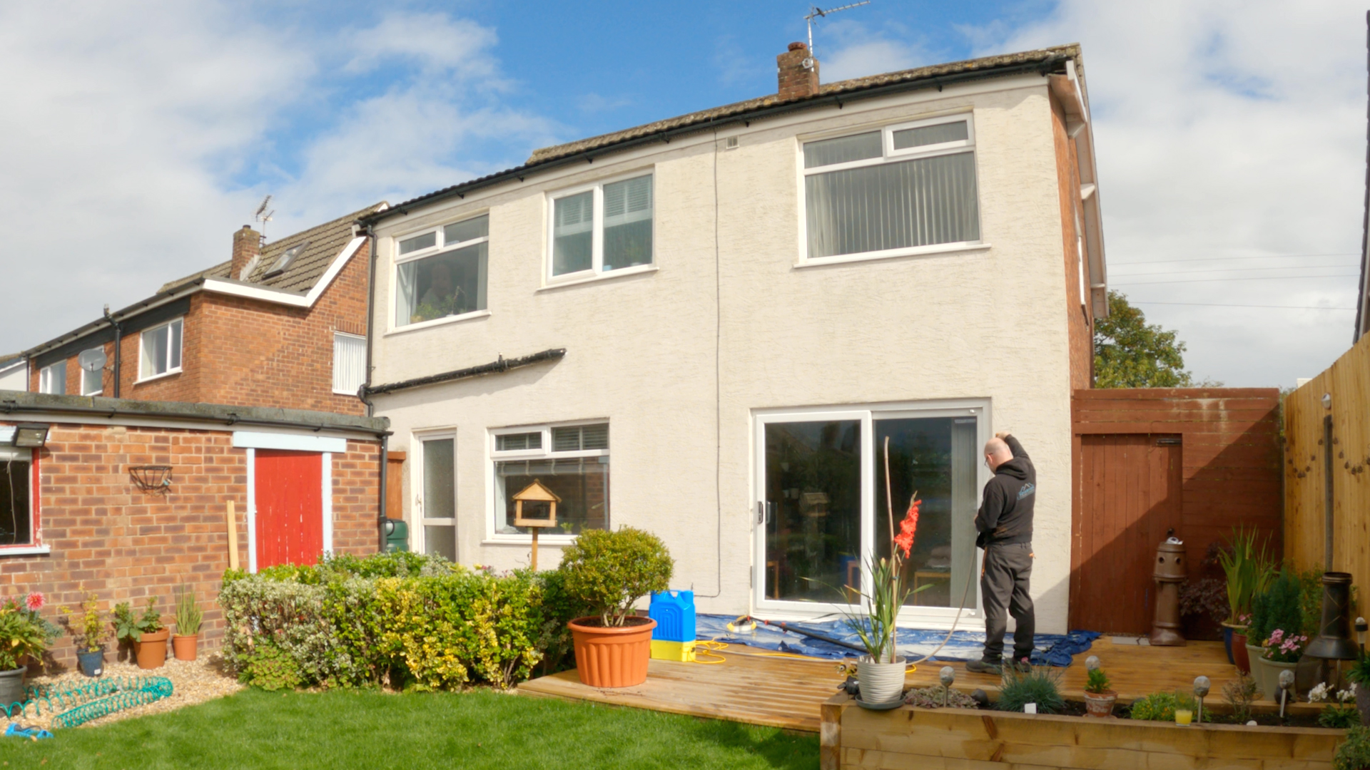 The same rendered house after soft washing, with the render back to a clean off-white