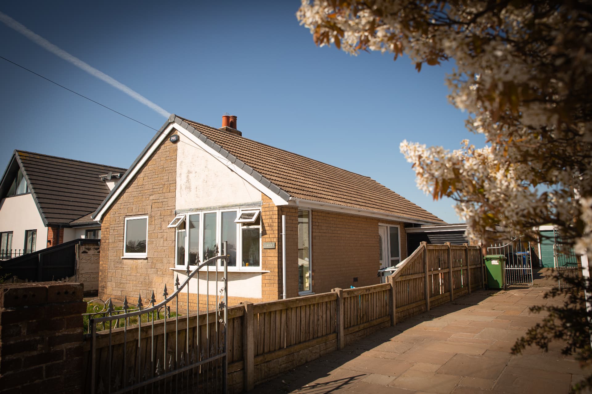 Clean bungalow exterior with tiled roof, white fascias and clear windows on a sunny day