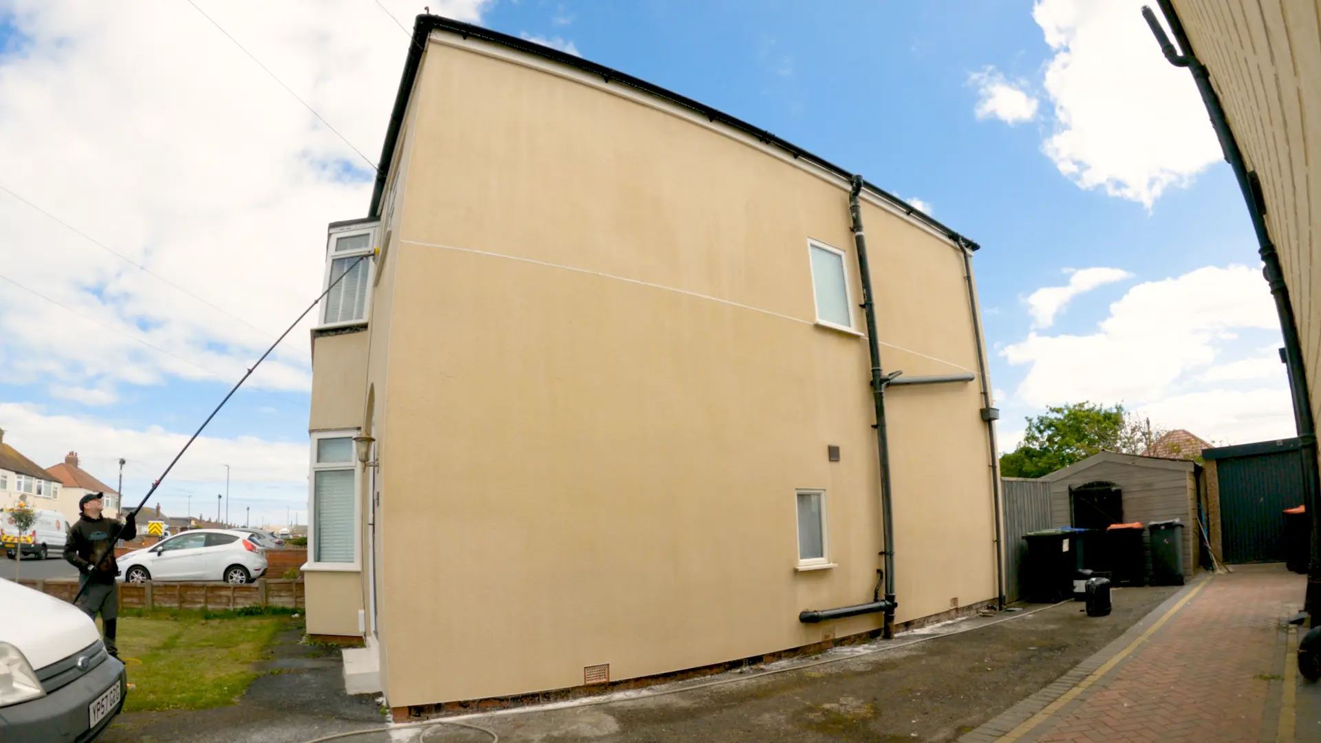 The same rendered gable wall after soft washing, cleaned evenly from ground to roofline